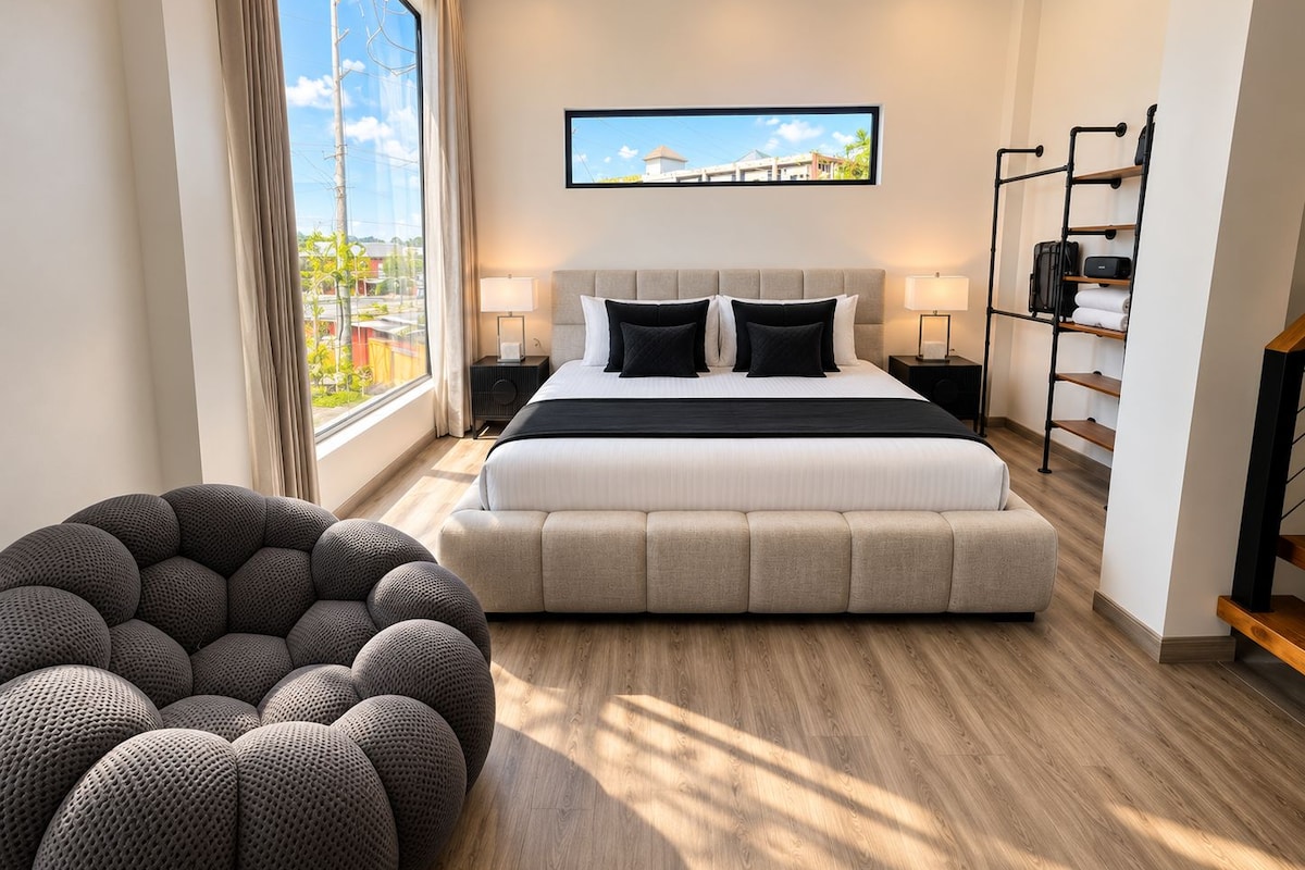 Una habitación de hotel moderna con una cama grande, vistas a la ciudad, un televisor y un armario.