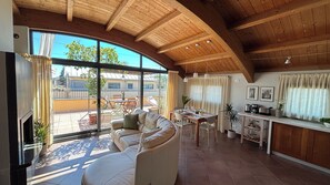 A spacious living area with a curved ceiling, a sofa, a dining table, and a view of the outside. - Almond Vista, Lucca Roof Garden (Lucca)