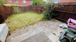 A backyard with a wooden fence, a gravel path, and a grassy area. - Modern 2BR Home | Base for Gower & Bay Campus (Swansea)