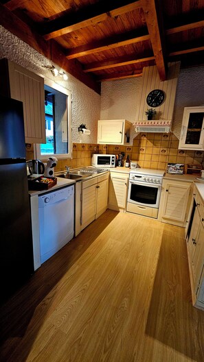 A kitchen with wooden cabinets, a microwave, an oven, and a sink.