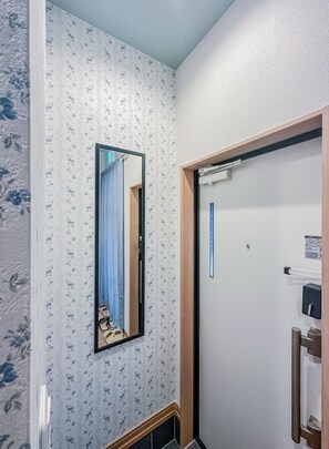 Ein Badezimmer mit Spiegel, Handtuchhalter und einer Tür mit Griff.