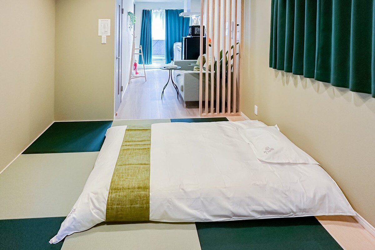 Ein Hotelzimmer mit Bett, Schreibtisch und Blick auf den Flur.