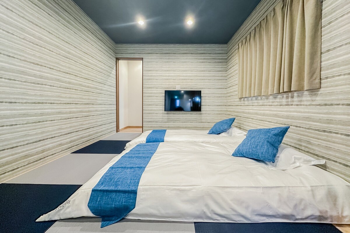 Ein modernes Zimmer mit einem Bett, einem Fernseher und einer Schiebetür.