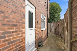 A narrow alleyway with a brick wall on one side and a wooden fence on the other. - Old Trafford Studio – Walk to Tram, 10 Mins to Manchester Centre (Manchester)