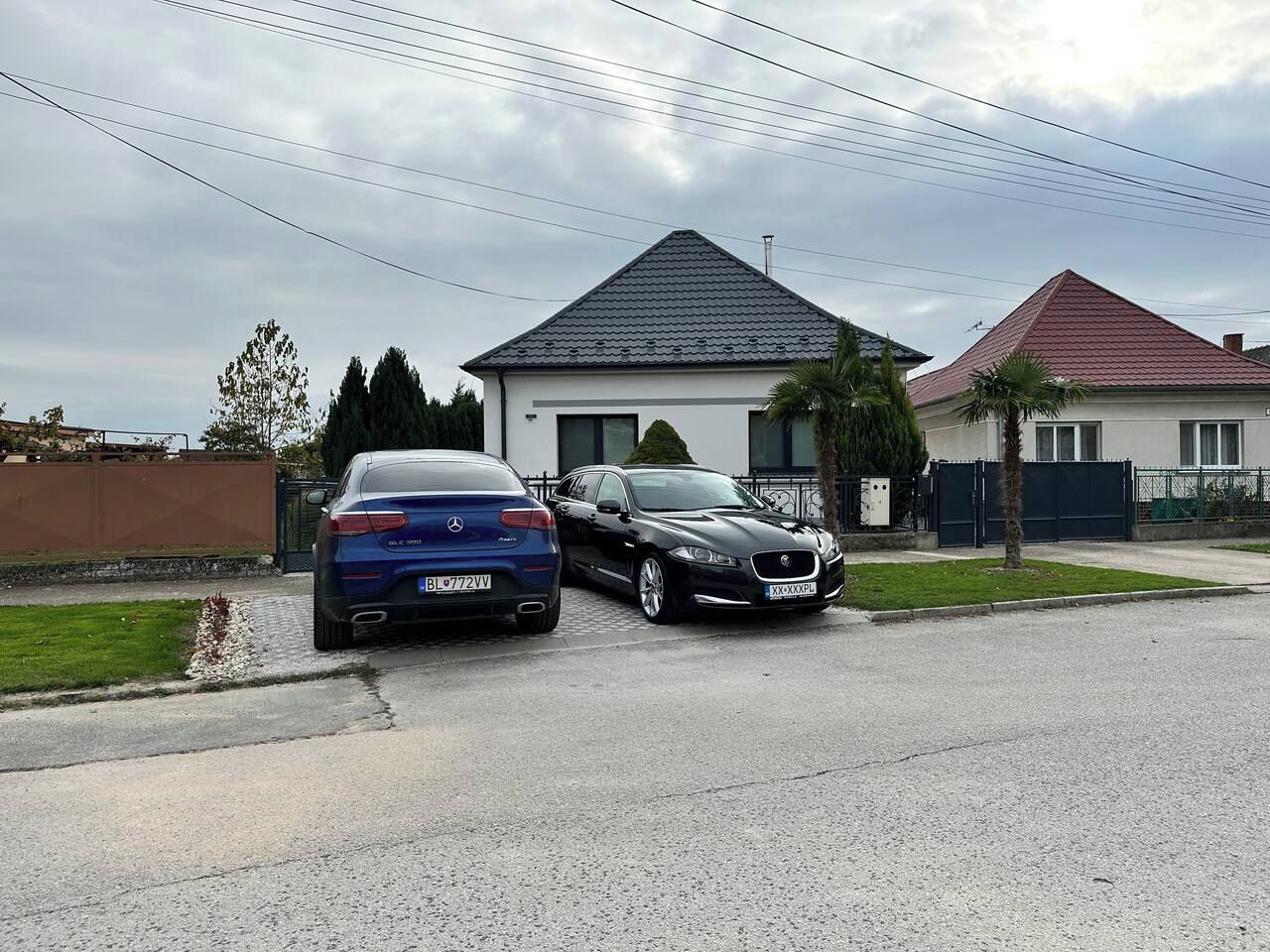 Eine Wohnstraße mit zwei geparkten Autos vor Häusern.