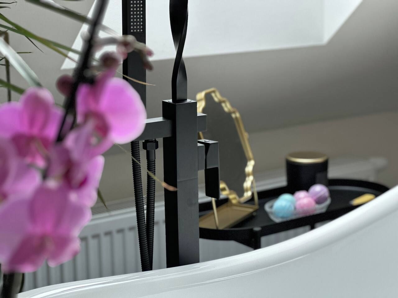 Un intérieur moderne aux couleurs contrastées, en noir et blanc, avec une structure noire au design incurvé, un mur blanc et un radiateur.