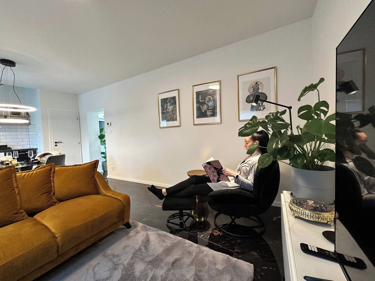Uma sala de estar moderna com sofá, poltrona, mesa de centro e planta em vaso.