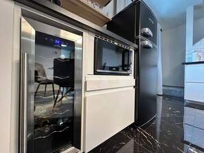 A kitchen with a built-in oven, microwave, and a refrigerator.