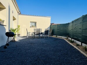 An outdoor patio area with a barbecue grill, two chairs, and a small table. - House with pets allowed - 6 guests (Hasnon)