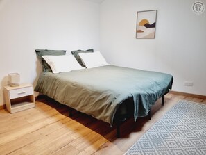 A bedroom with a bed, a nightstand, a lamp, a rug, and a wall art piece. - House with pets allowed - 6 guests (Hasnon)