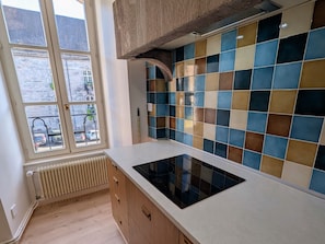 A kitchen with a window, a radiator, and a tiled backsplash. - Chic apartment in Luxeuil-les-Bains - 4 guests (Luxeuil-les-Bains)
