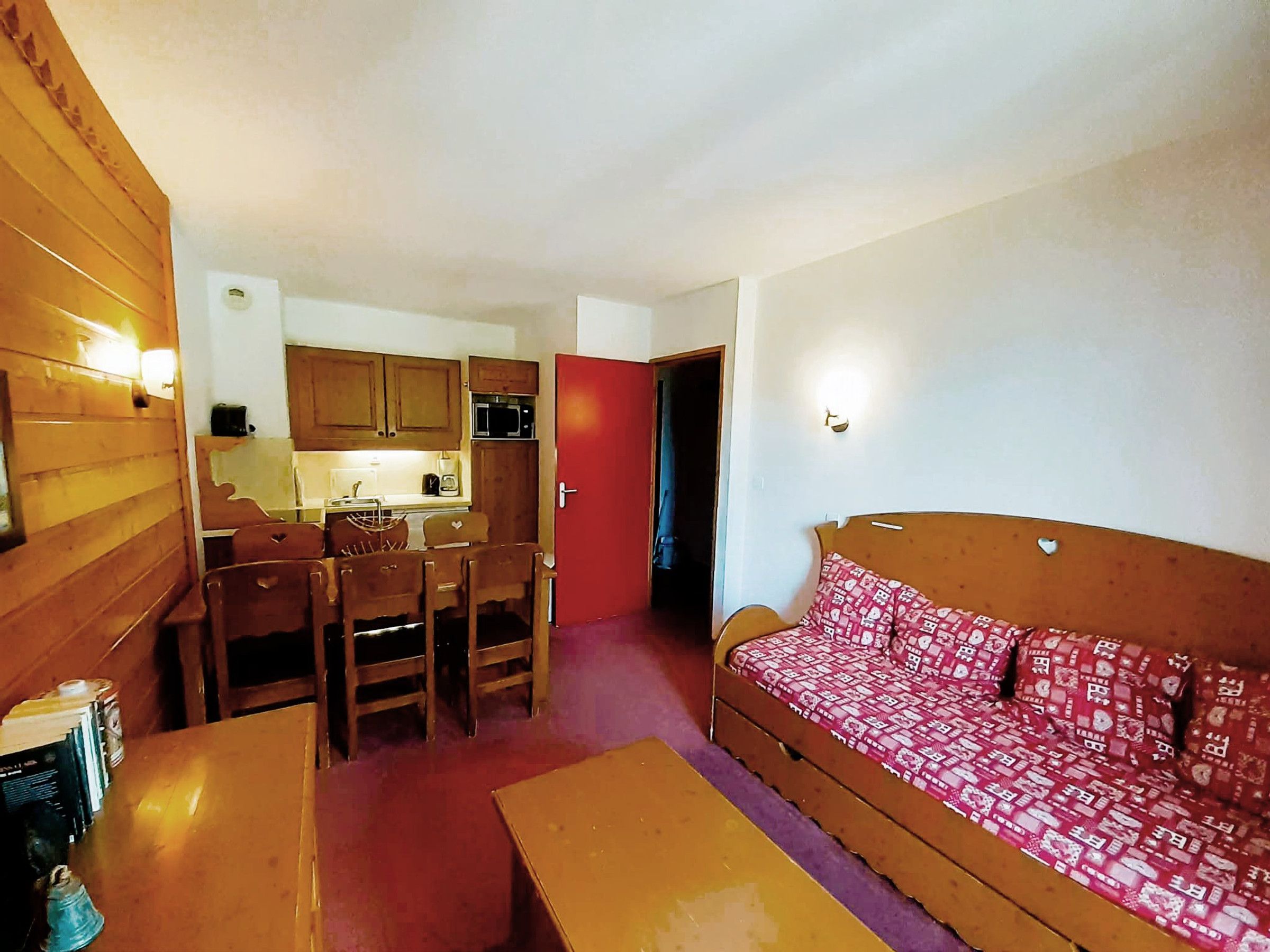 A compact living space with a dining area, kitchenette, and a sofa.