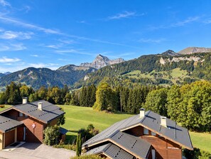 A mountain landscape with two wooden cabins featuring sloped roofs and chimneys. - Apartment facing Mont Charvin (Notre-Dame-de-Bellecombe)