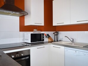 A kitchen with white cabinets, a microwave, a sink, and a dishwasher. - Cozy duplex, pets welcome - 8 guests (Bolquère-Pyrénées 2000)