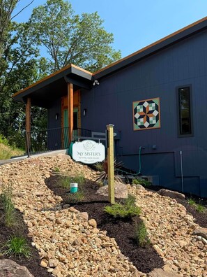 A building with a sign reading 'My Sister's Sewing Sanctuary' and a geometric wall art piece. - Parkville Group Getaway - Sleeps 12 with 12 Individual Workstations (Parkville)