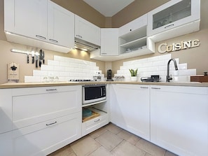 A modern kitchen with white cabinetry, a built-in oven, a microwave, and a coffee machine. - Le Jasmin: Your cozy retreat in the heart of Provence (Trans-en-Provence)