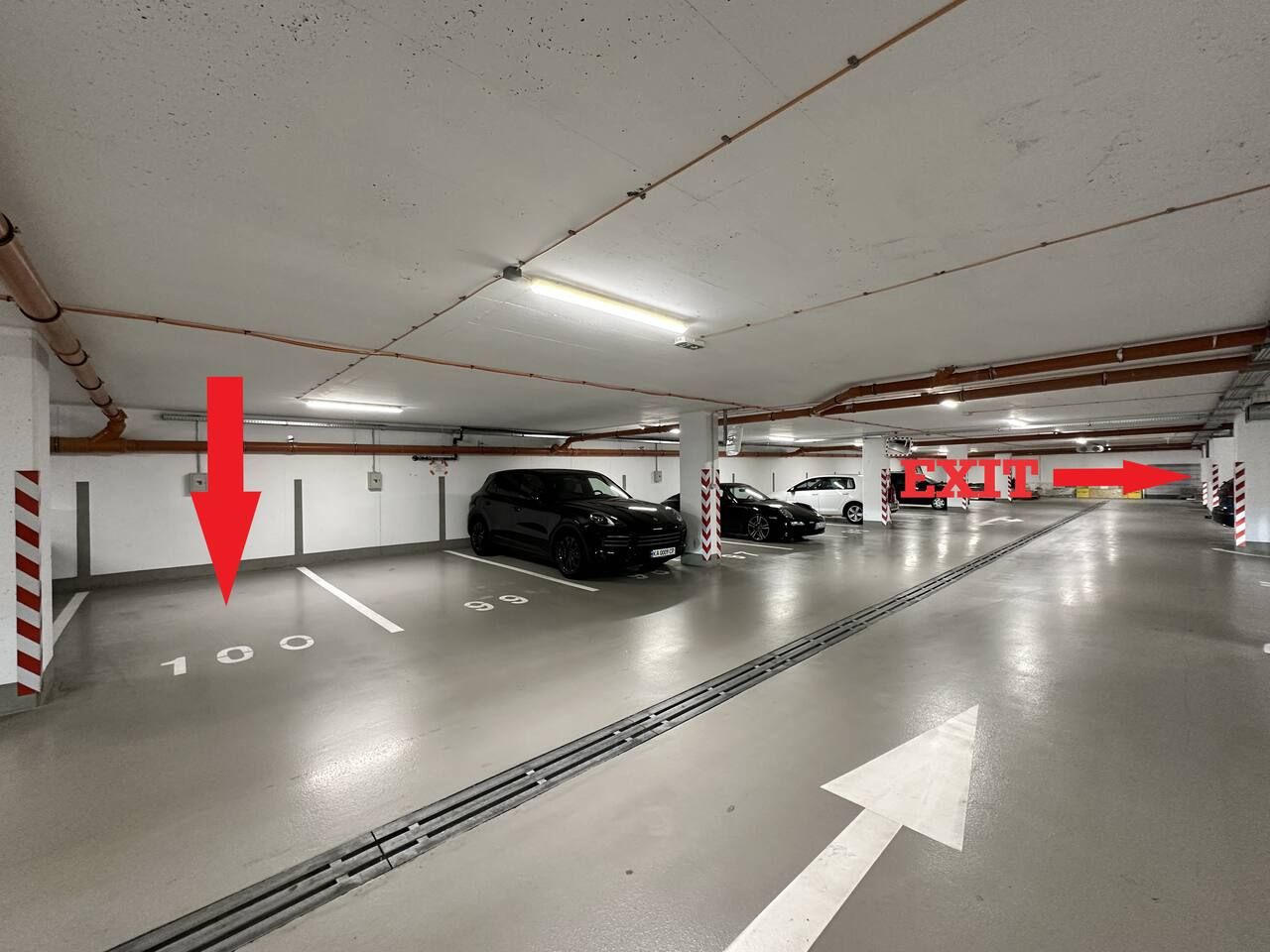 Un estacionamiento de varios niveles con espacios claramente delimitados y flechas direccionales.