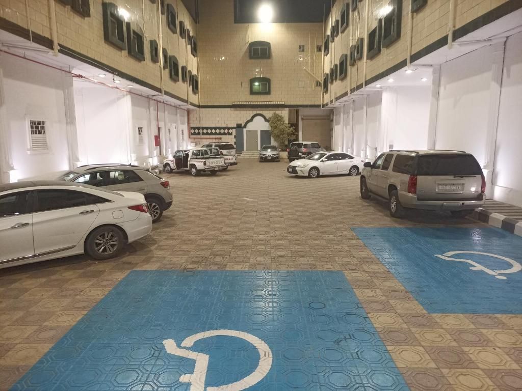 A parking garage with multiple levels, cars parked, and blue handicap-accessible parking spaces.