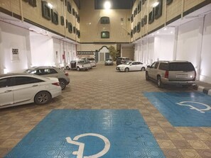 A parking garage with multiple levels, cars parked, and blue handicap-accessible parking spaces.