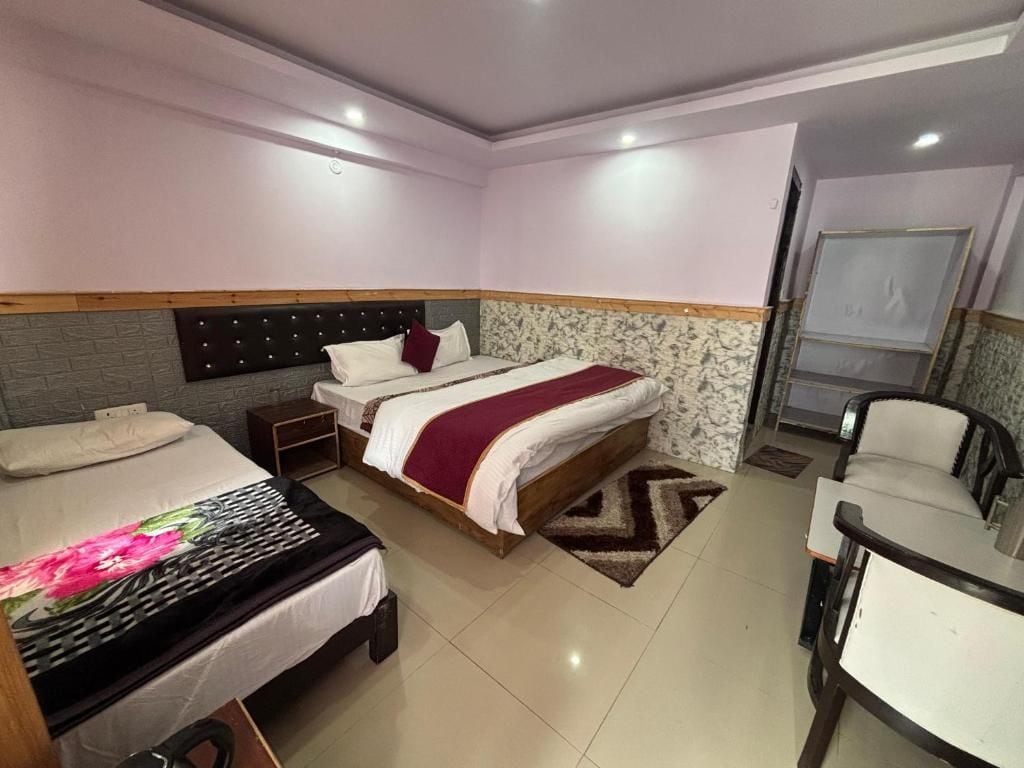 Een hotelkamer met twee bedden, een zithoek en een badkamer.