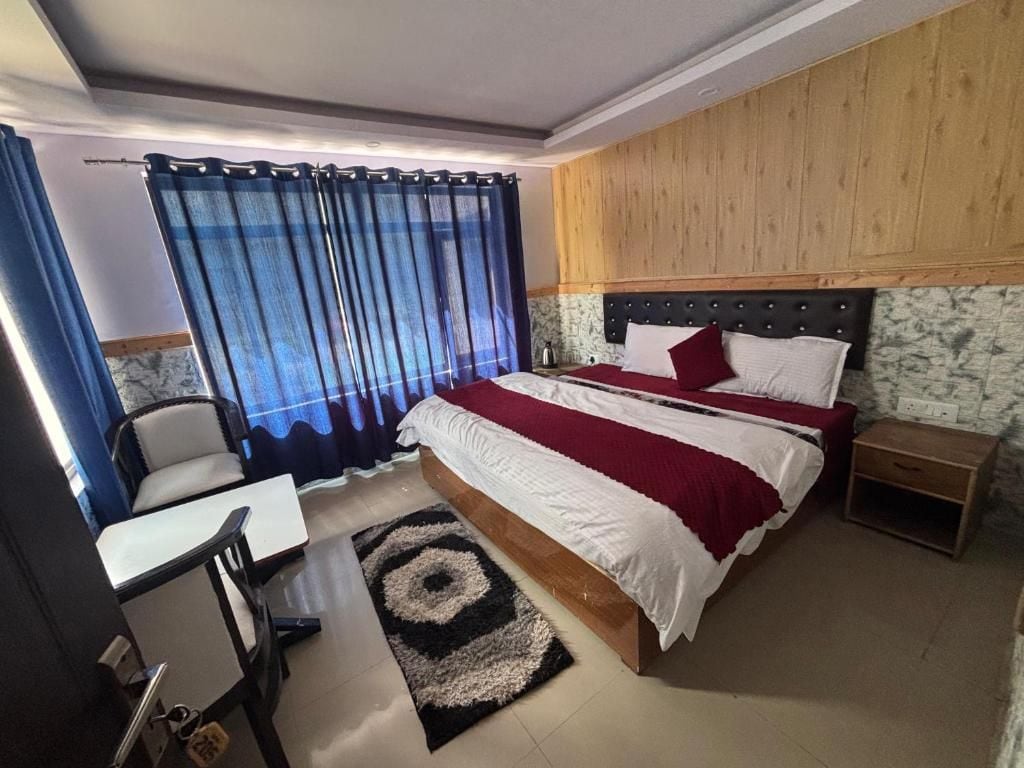 Ein Schlafzimmer mit einem Bett, einem Schreibtisch, einem Sessel und einem Nachttisch.