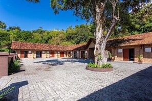 A courtyard with a paved ground, surrounded by buildings with red-tiled roofs and brick walls. - Inn w/ Shared Kitchen 780m From Beach Dab0012 (Porto Seguro)