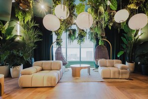 Ein modernes Wohnzimmer mit zwei Sofas, einem Couchtisch und hängenden Pflanzen.