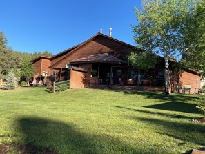 A wooden cabin with a porch, a covered outdoor seating area, and a well-maintained lawn. - NEW LISTING! Lakefront Home for Rest and Recreation (Pagosa Springs)