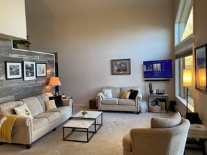 A living room with two sofas, a coffee table, a TV, and framed pictures on the wall. - NEW LISTING! Lakefront Home for Rest and Recreation (Pagosa Springs)