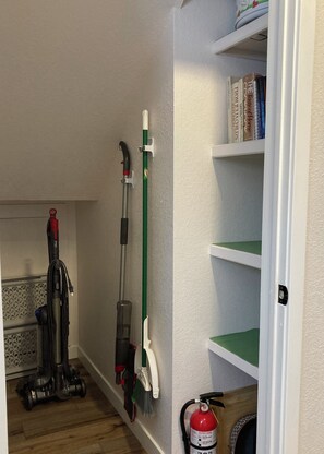 A hallway with a vacuum cleaner, a broom, and a fire extinguisher on the wall. - NEW LISTING! Lakefront Home for Rest and Recreation (Pagosa Springs)