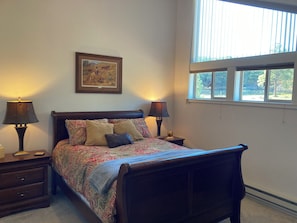 A bedroom with a bed, two bedside lamps, a framed picture on the wall, and a window with blinds. - NEW LISTING! Lakefront Home for Rest and Recreation (Pagosa Springs)