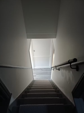 A staircase with a handrail, leading to a landing with a window. - Stylishly Restored House in Oulton Village, between The Broads and The North Sea (Lowestoft)