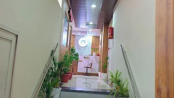 Zona de recepción de un hotel con mostrador, un reloj y un extintor.