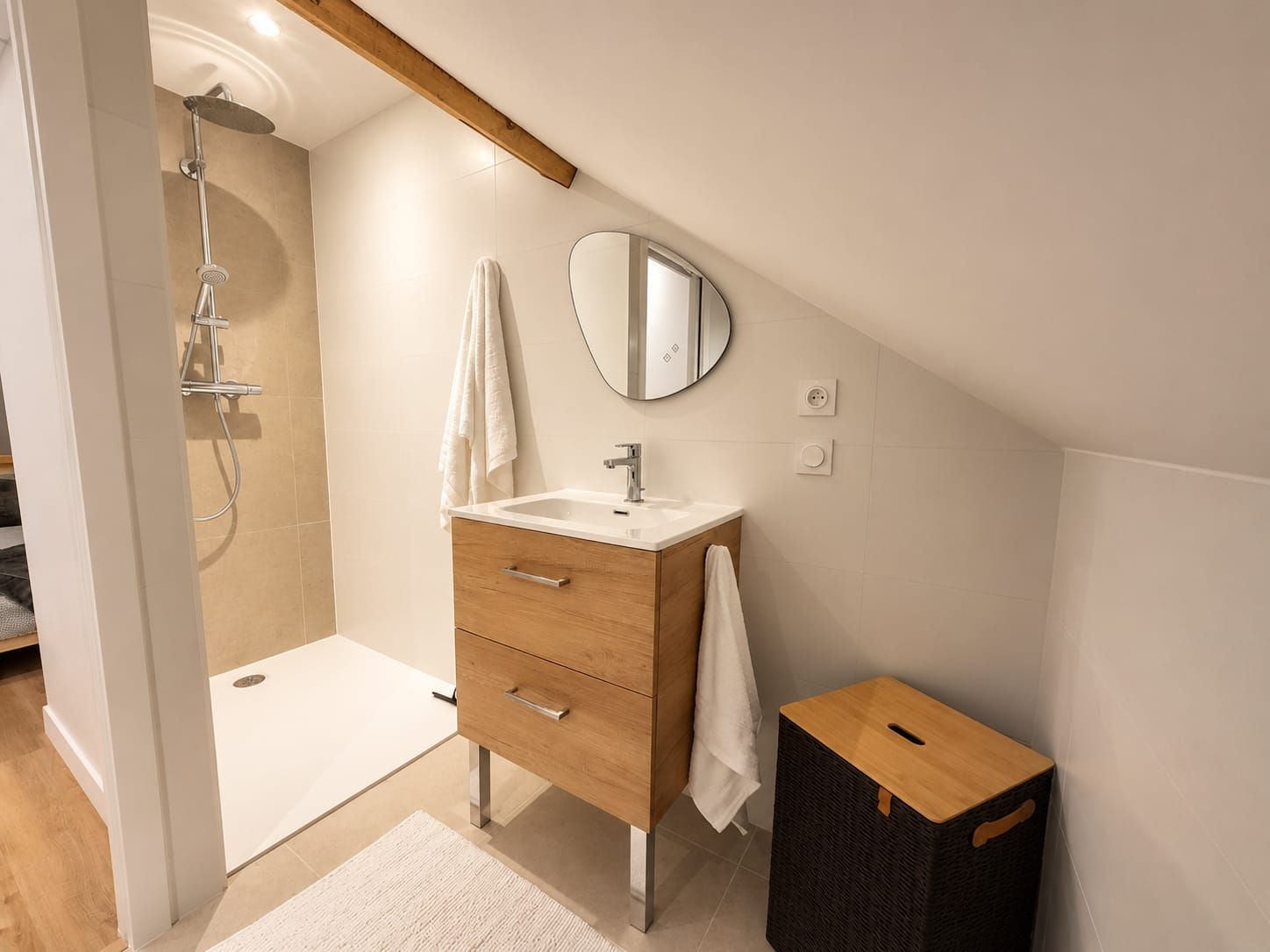 A modern bathroom with a shower, a sink, and a mirror.