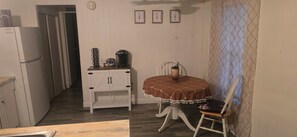 A compact kitchen with a refrigerator, a coffee maker, and a small cabinet. - The Colorado Cowboy Hideaway - a 3 bed, 2 bath gem located in Bullhead City! (Bullhead City)