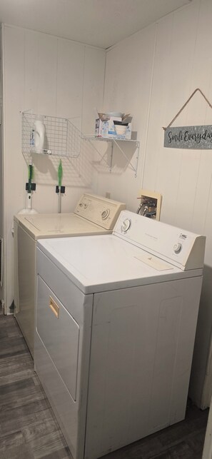 A laundry room with a front-loading washing machine, a drying rack, and a shelf with cleaning supplies. - The Colorado Cowboy Hideaway - a 3 bed, 2 bath gem located in Bullhead City! (Bullhead City)
