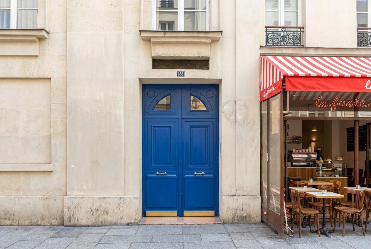 A blue double door with a small window, a number '168' above it, and a red and white striped awning to the right.