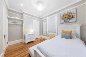 A bedroom with a bed, bedside tables, a dresser, a mirror, and a painting on the wall. - Walk to Downtown, Shops, Restaurants! Charming Historic Home, Screened Porch, $300 in Free Tickets! (St. Augustine)
