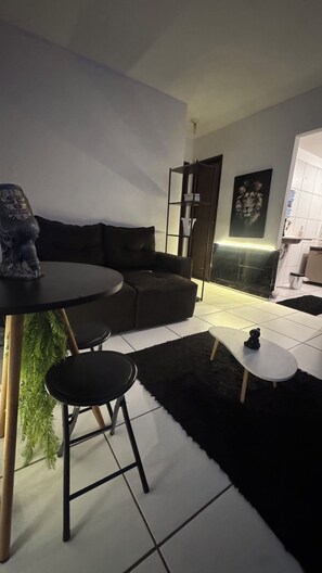 A modern living room with a sectional sofa, a small round table, and a coffee table. - Room with pool view in gated community (Vitória de Santo Antão)