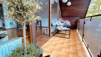 A modern outdoor seating area with a wooden ceiling and a glass wall.