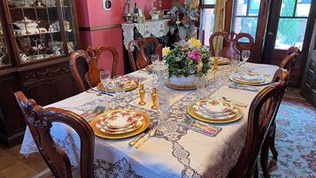 A dining room with a table set for six, surrounded by wooden chairs.