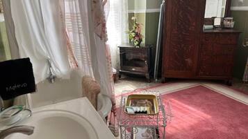 A bathroom with a white sink, a mirror, a vanity, a wooden cabinet, and a red carpet.
