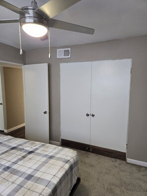 A bedroom with a bed, a ceiling fan, and two wardrobes. - Charming Bedroom in shared 2 bed 1 bath apartment by the Galleria! (Houston)