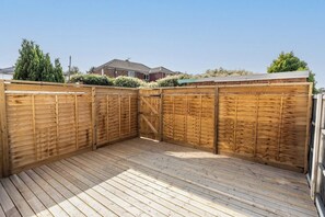A wooden deck with a gated area, surrounded by a fence and greenery. - Contractor • 3 Bed Home • Street Parking • Wi-Fi (Halton)