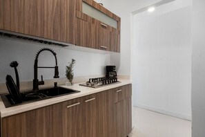 Eine moderne Küche mit Einbaugasherd, Spüle und Holzschränken.