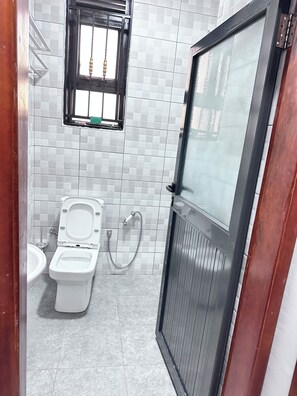 Un baño con inodoro, bidé y ventana.