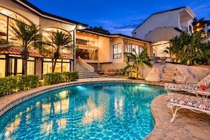 A swimming pool with a stone edge, surrounded by a patio with lounge chairs. - Ocean View Villa • Tamarindo 5 min • Walk to Beach (Tamarindo)
