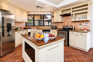 A modern kitchen with a central island, stainless steel appliances, and a tiled backsplash. - Ocean View Villa • Tamarindo 5 min • Walk to Beach (Tamarindo)