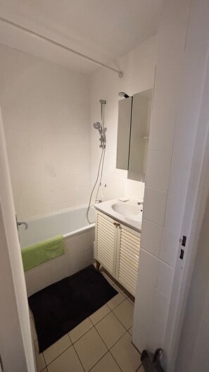 Ein Badezimmer mit Badewanne, Waschbecken, Spiegel und Dusche.