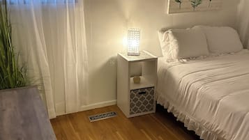 Ein Schlafzimmer mit einem Bett, einem Nachttisch und einem Beistelltisch mit Lampe.